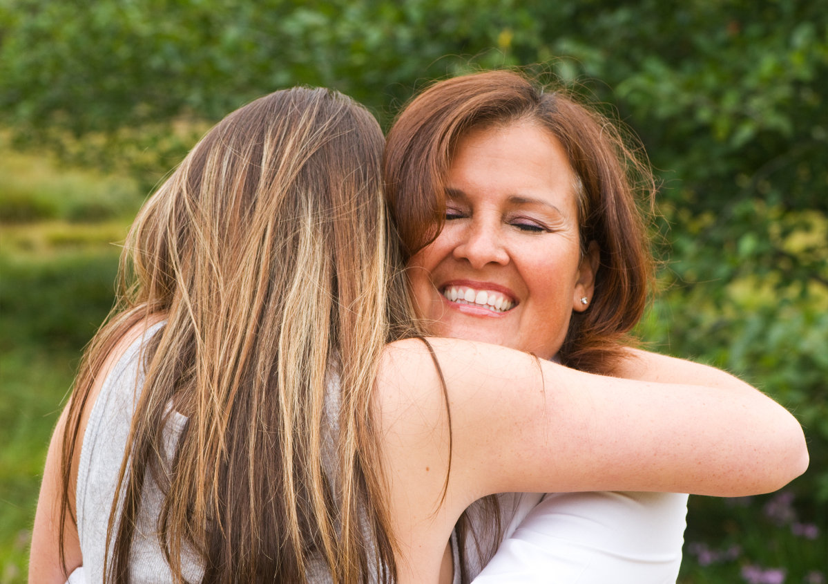 Mum hugging her teen daughter