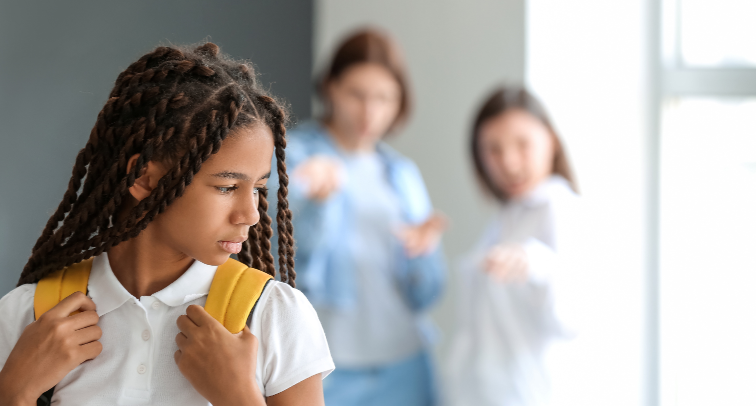 Girl being bullied by other girls in a corridor