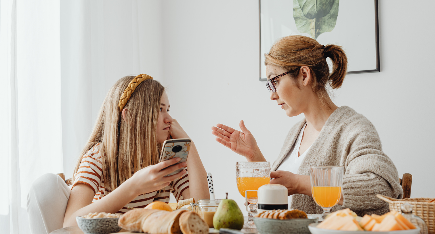 Mum talking to her teen daughter at the breakfast table