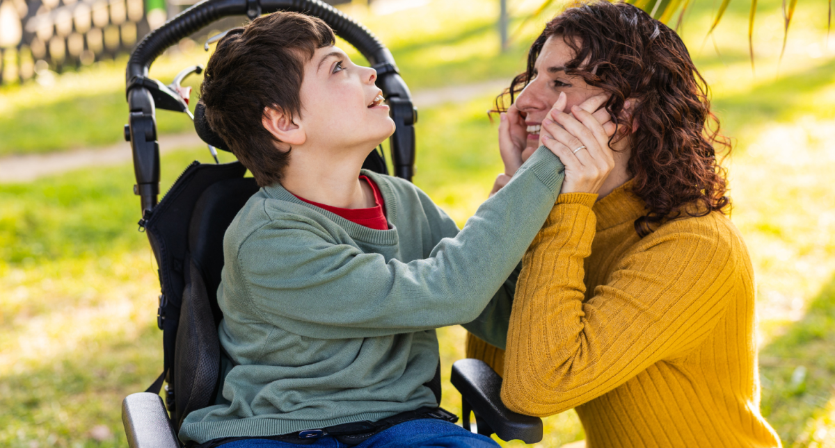 child playing with mother outdoors in wheelchair, cerebral palsy and intellectual disability awareness