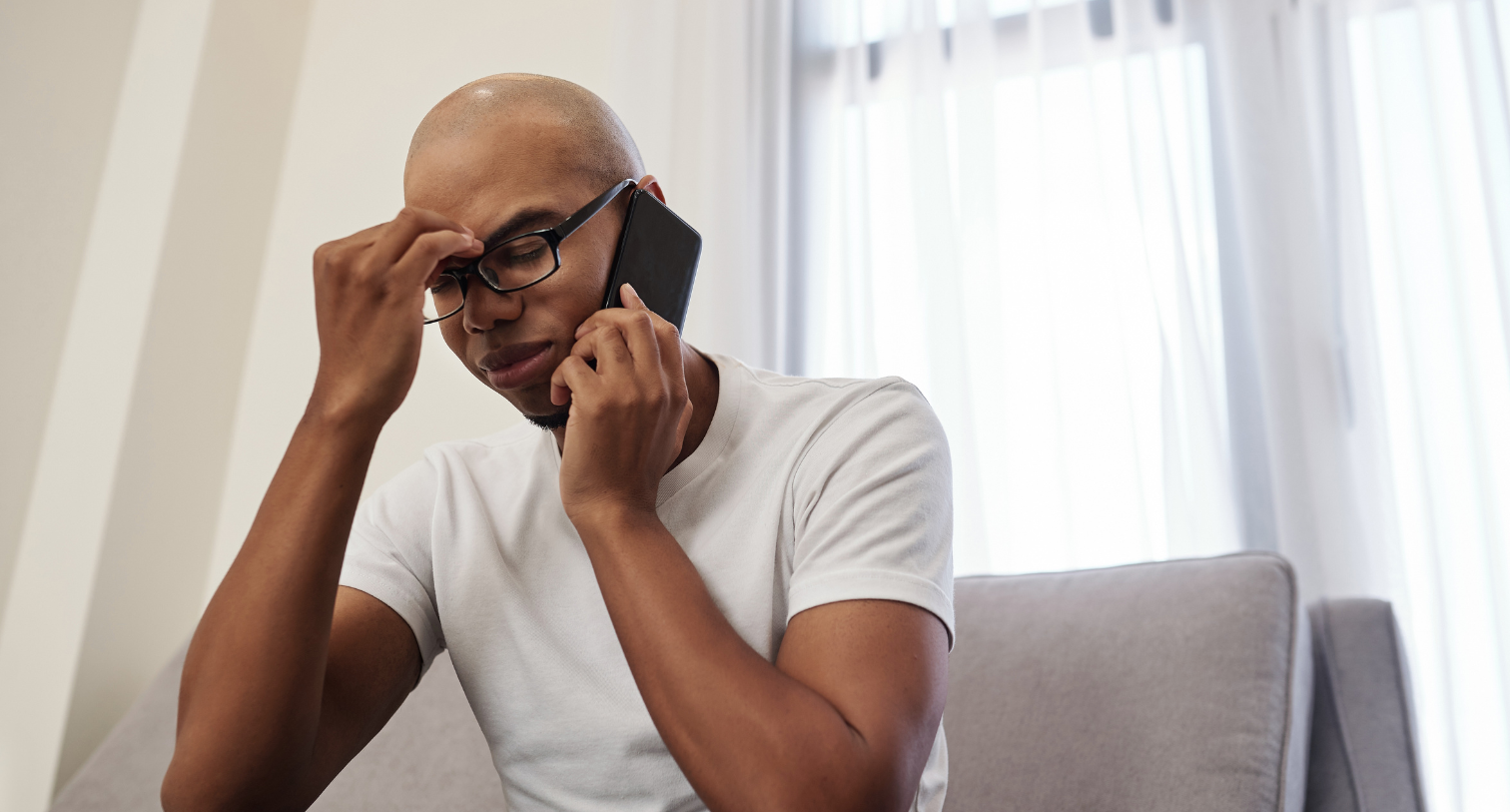 Stressed man making a phone call whilst sitting down