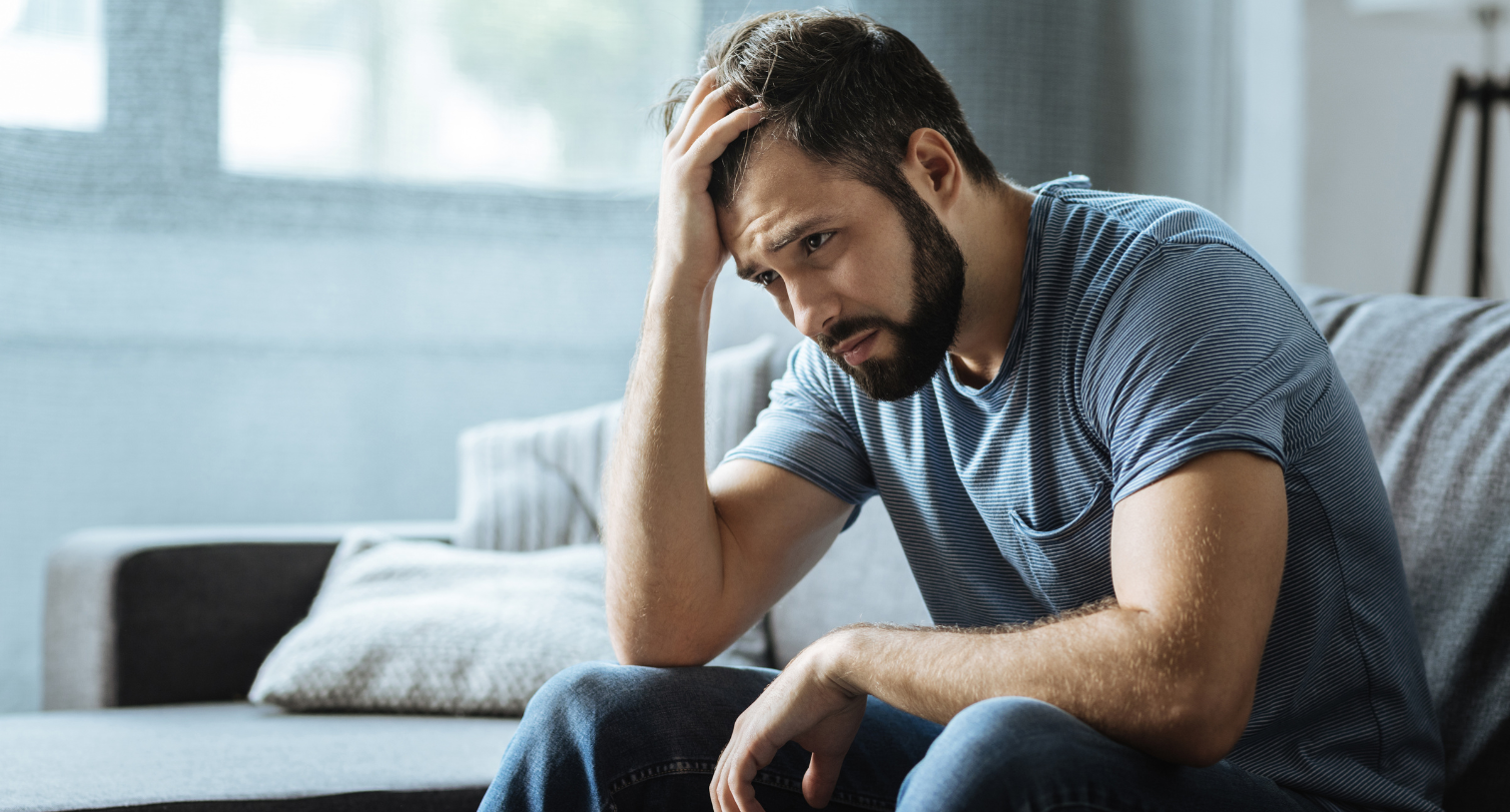 Sad man holding his forehead