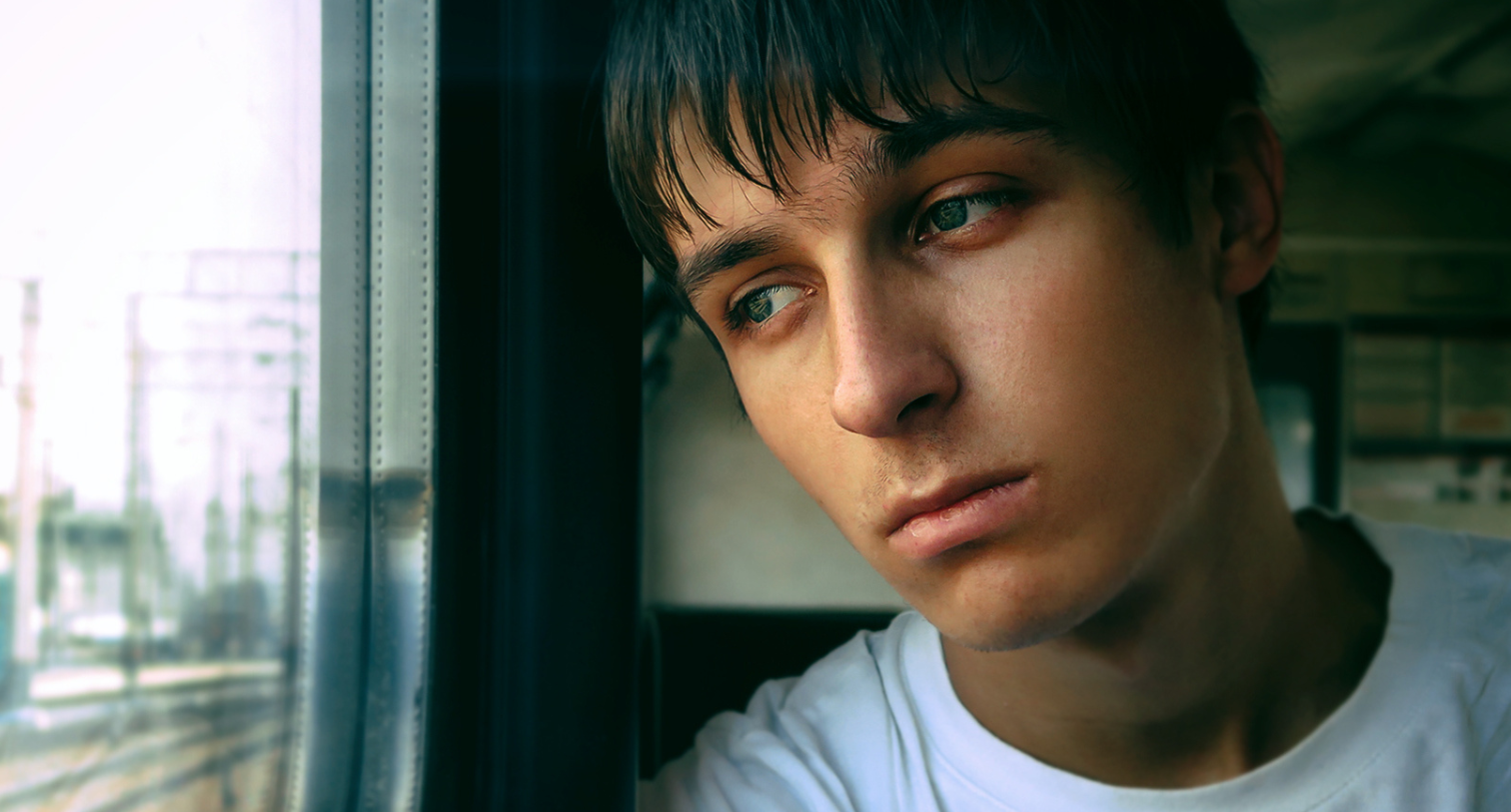 Sad teen boy on train