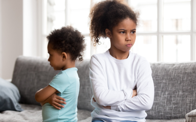Two siblings unhappy with each other with their backs to one another