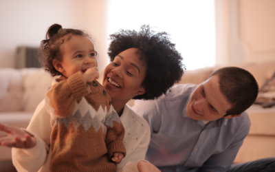 Mum and dad playing with their young daughter and having fun.