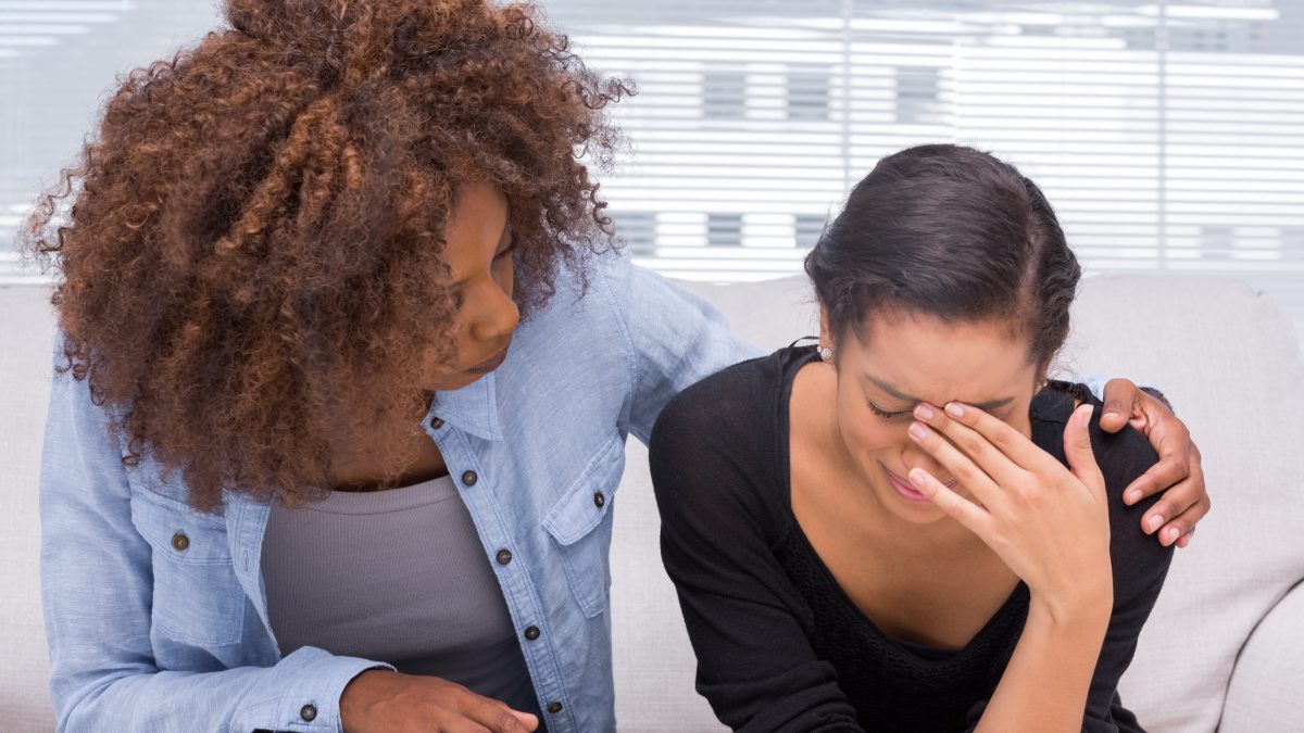 Woman crying and being comforted by another woman